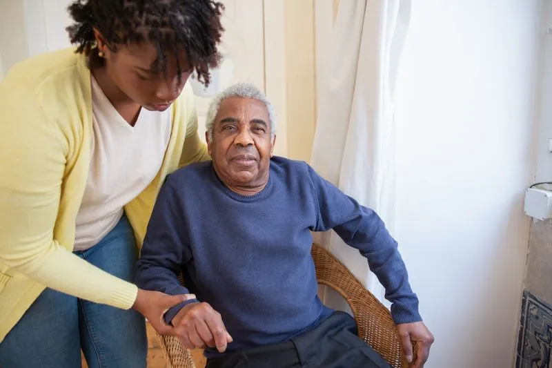 An elderly person carefully holding a stair bannister while navigating stairs at home