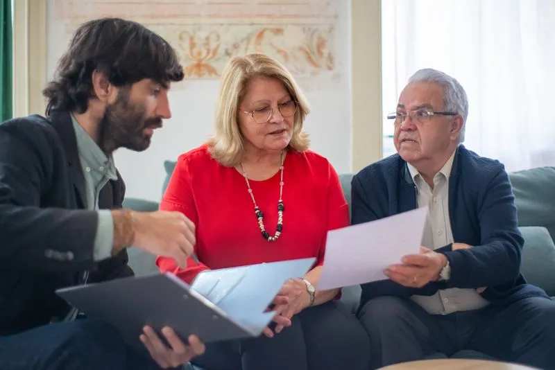 A friendly professional discussing options with an elderly couple at home